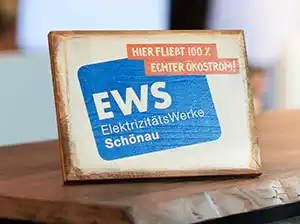 Holzaufsteller mit Text "Hier fließt 100% Ökostrom" und EWS-Logo