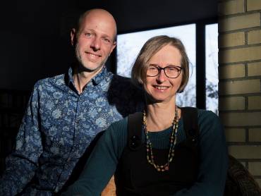 Die greenap-Gründer Georg Amshoff und Sabine te Heesen stehen im Freien vor einer hellen Ziegelwand.
