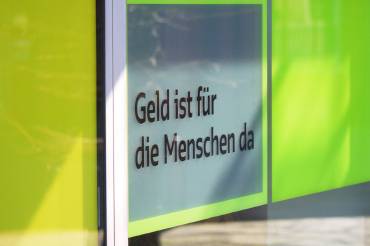 Eingangstür der GLS Bank mit Claim «Geld ist für die Menschen da»