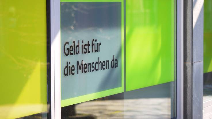 Eingangstür der GLS Bank mit Claim «Geld ist für die Menschen da»