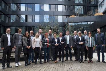 Gruppenbild von Menschen auf einer holzvertäfelten Terrasse