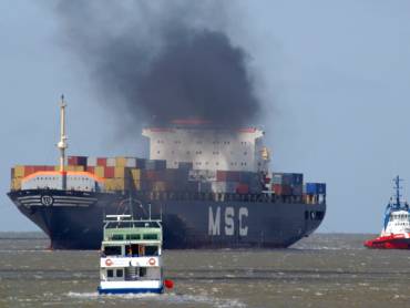 Containerschiff mit schwarzem Dieselqualm