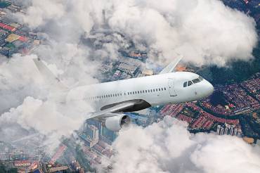Flugzeug steigt in die Luft über einer Großstadt