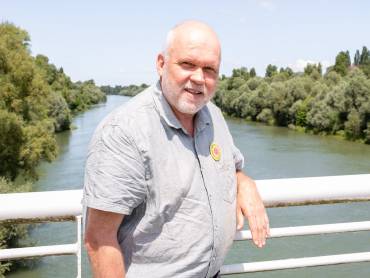 Portrait eines älteren Mannes, auf auf einer Brücke stehend.