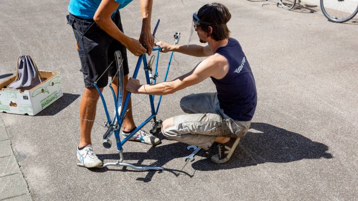 Ein junger Mann schaut sich einen Fahrradrahmen an.