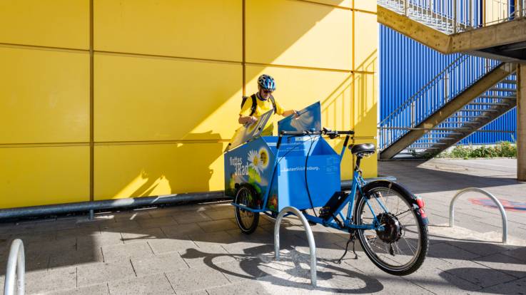 Ein Mann steht hinter einem Lastenfahrrad und schaut in die Transportox.