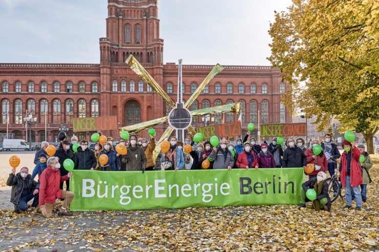 Some 40 people are lined up for a group photo in front of Berlin’s town hall, the Rotes Rathaus. Behind them, a cardboard cut-out of the TV Tower radiates golden sunbeams.