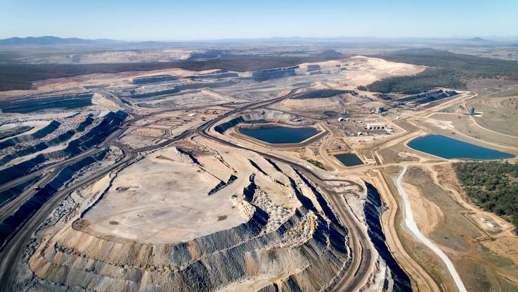 Vogelperspektive: Wie eine karge Mondlandschaft aus Terrassen und Wasserbecken zieht sich ein Tagebau durchs Land. 