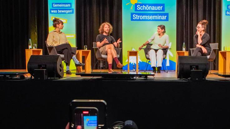 Drei Frauen und ein Mann sitzen auf der Bühne und diskutieren angeregt miteinander. 