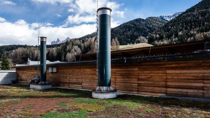 Two grey chimneys rise from the succulent-covered roof of the heating plant.  