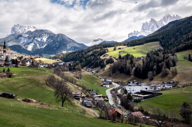 View of a picturesque alpine valley, snow-covered mountains in the background.