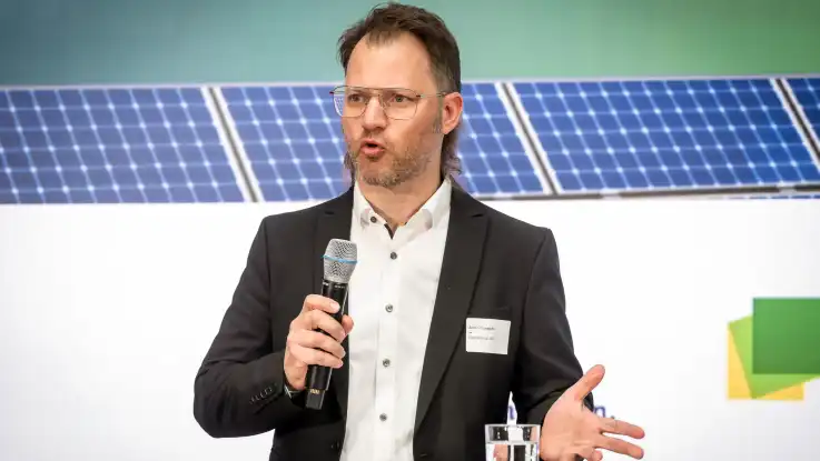 Der Mann mit dem grau melierten Bart hält nun eine Rede, dabei schaut er mit wachem Blick nach vorne.